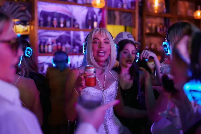 asistentes con auriculares inalámbricos iluminados disfrutando de una fiesta